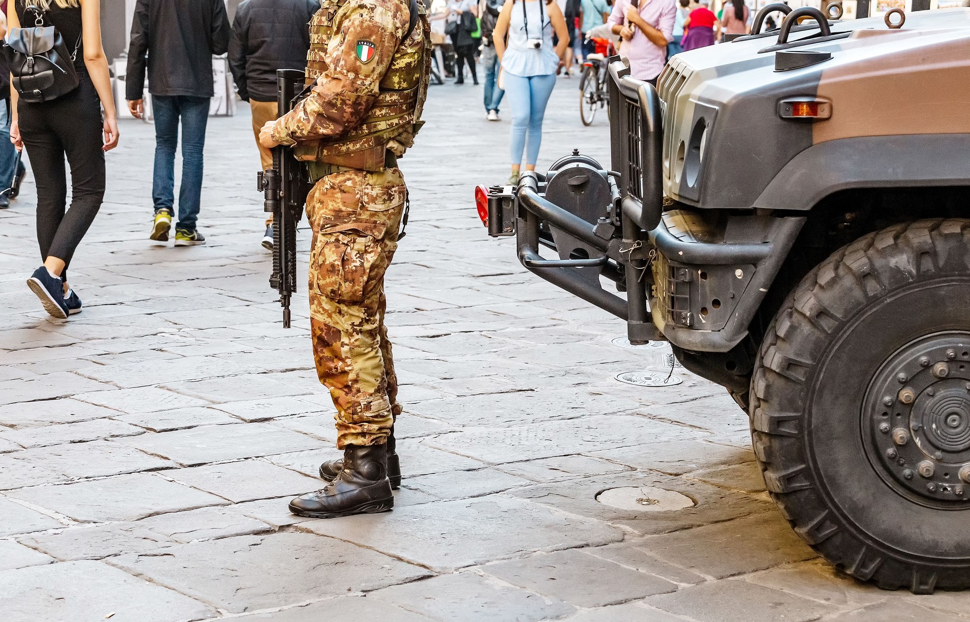 polizia militare italiana in uniforme completa e armato nella strada trafficata città